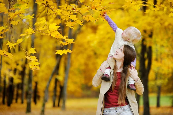 Ung mamma och barn girl ha roligt på hösten — Stockfoto