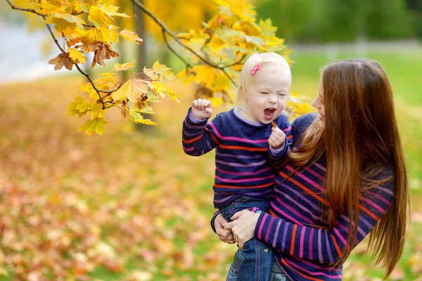 年轻的母亲和蹒跚学步的女孩在秋天有乐趣 — 图库照片