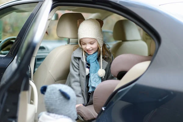 Menina entrando em seu assento de carro — Fotografia de Stock