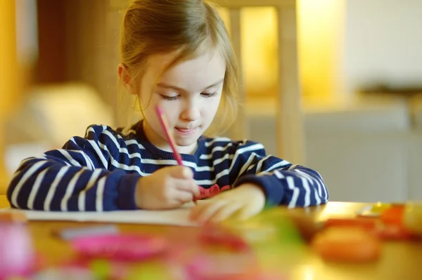 Schattig klein meisje is tekenen met potloden — Stockfoto