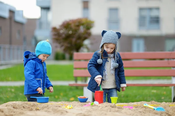 Two kids playing in a sandbox — Stock Photo, Image