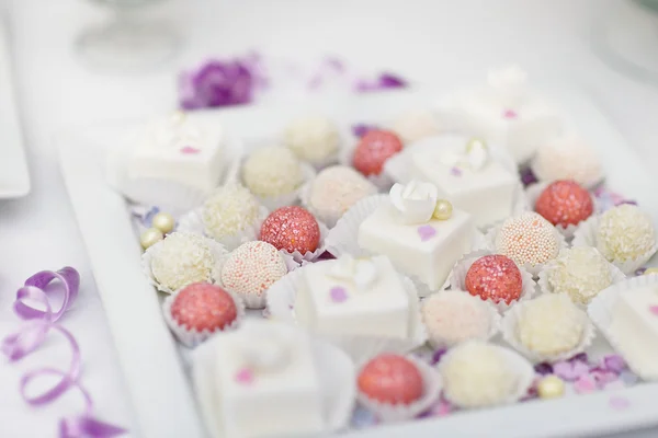 Kleurrijke snoepjes op een witte plaat ingericht — Stockfoto
