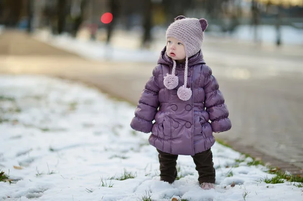 Batole dívka baví zimního dne v městě — Stock fotografie