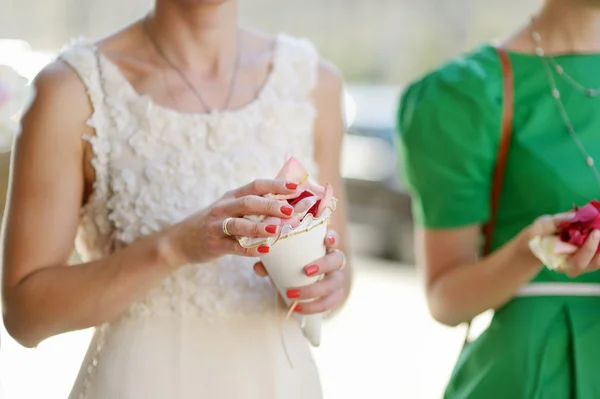 Mujer sosteniendo pétalos de rosa en la boda —  Fotos de Stock