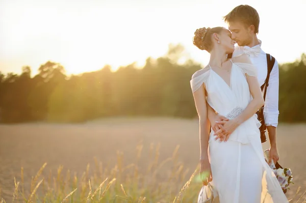 Braut und Bräutigam am Strand bei Sonnenuntergang — Stockfoto