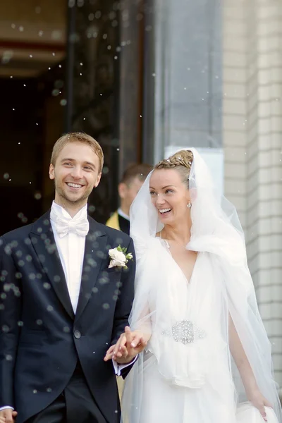 Pareja casada bajo una lluvia de arroz — Foto de Stock