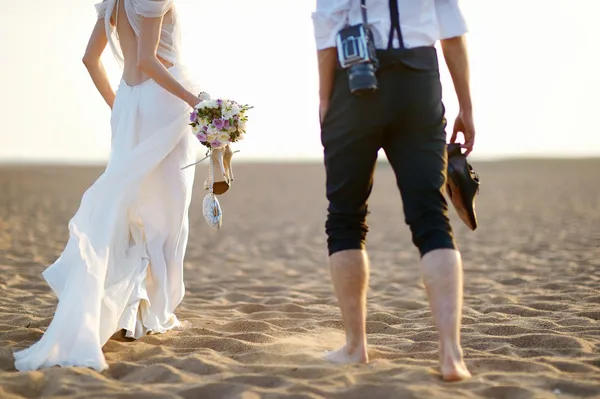 Braut und Bräutigam am Strand bei Sonnenuntergang — Stockfoto