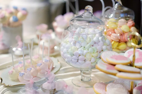 Украшенные красочные конфеты на розовом столе — стоковое фото