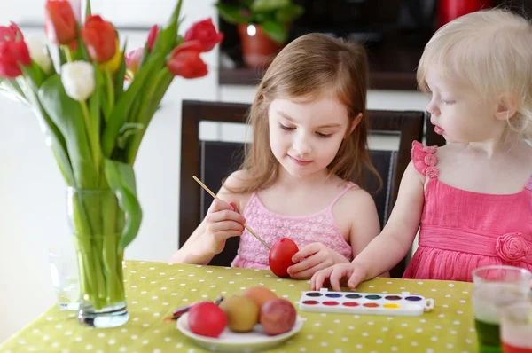 Two little sisters painting Easter eggs — Stock Photo, Image