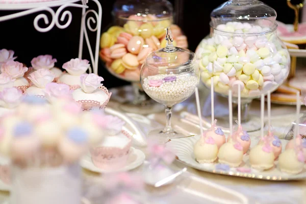 Dekorierte bunte Bonbons auf einem weißen Tisch — Stockfoto