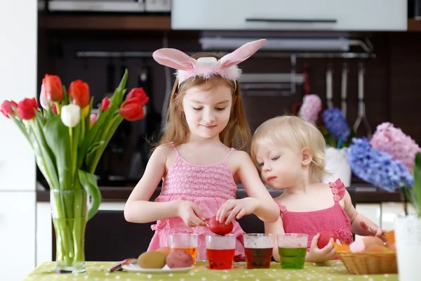 Twee kleine zusters schilderij paaseieren Stockfoto