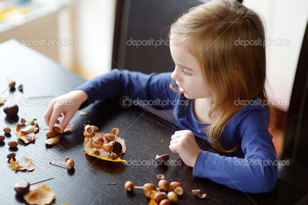 Little girl making chestnuts creatures