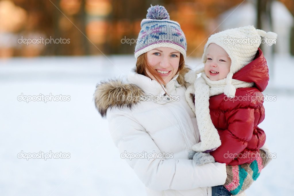 Young mother and her toddler daughter at winter