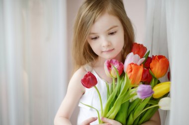 pencerenin yanındaki Lale ile sevimli küçük kız