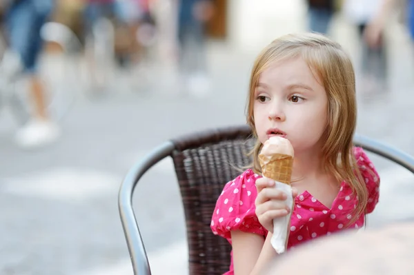 Очаровательная маленькая девочка ест мороженое на открытом воздухе — стоковое фото