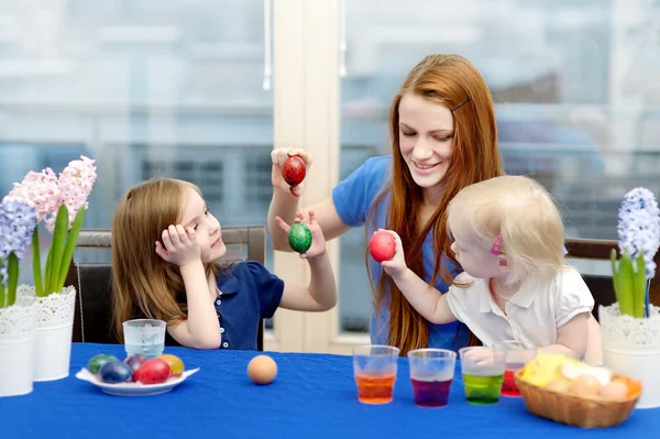 Mother and her daughters painting Easter eggs — Stock Photo, Image