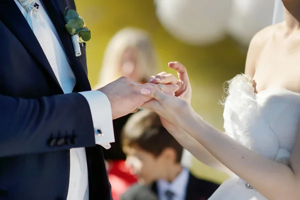 Bride is putting the ring on groom's finger — Stock Photo, Image