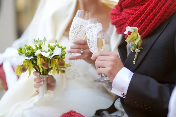 Bride and groom holding champagne glasses — Stock Photo, Image