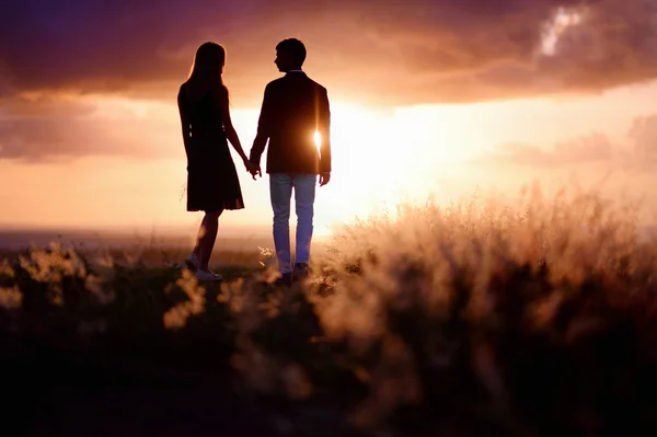 Молода пара насолоджується заходом сонця — стокове фото