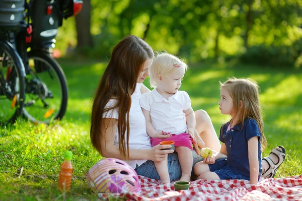 Giovane madre e le sue figlie a fare un picnic — Foto Stock