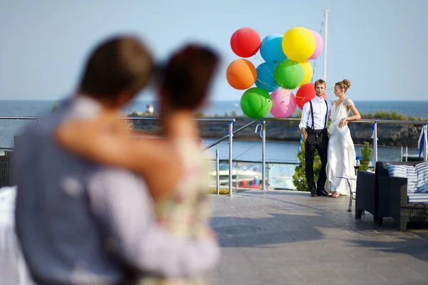 Lyckliga bruden och brudgummen med ballonger — Stockfoto