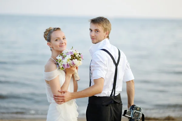 Beach wedding: bride and groom by the sea — Stock Photo, Image