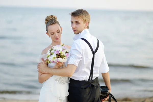 Strand bruiloft: bruid en bruidegom door de zee — Stockfoto