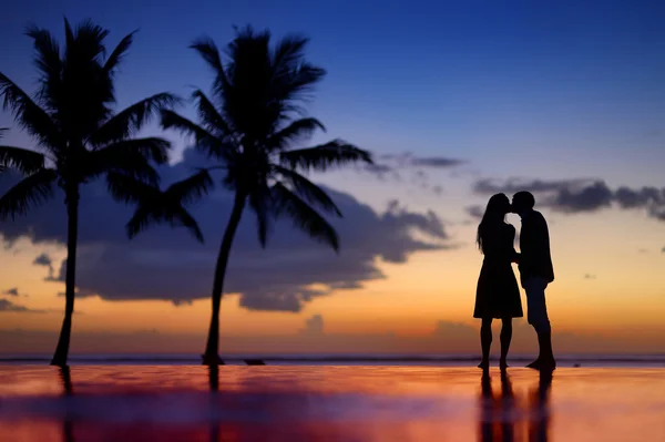 Silhouettes of young couple at scenic sunset — Stock Photo, Image