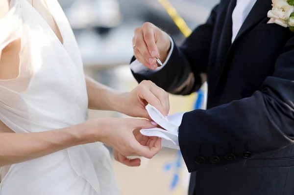 Braut hilft ihrem Bräutigam mit Manschettenknöpfen — Stockfoto