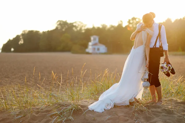 Mariée et marié sur une plage au coucher du soleil — Photo