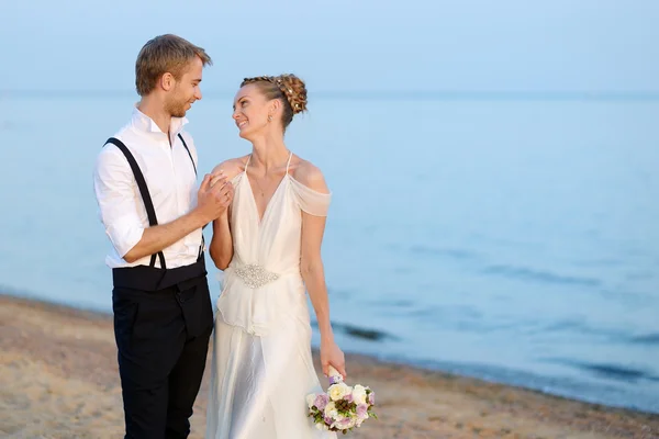 Beach wedding: bride and groom by the sea — Stock Photo, Image