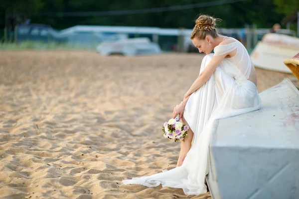 Beautiful bride sitting on a boat — Stock Photo, Image