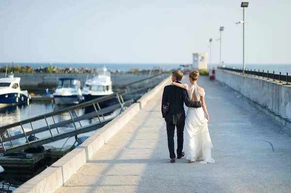 幸福的新娘和新郎在码头上行走 — 图库照片