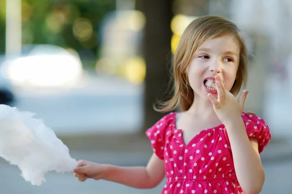 Urocza dziewczynka jedzenie cukierków nici na zewnątrz — Zdjęcie stockowe
