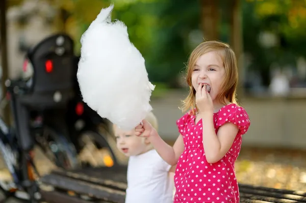 Entzückendes kleines Mädchen isst Zuckerwatte im Freien — Stockfoto