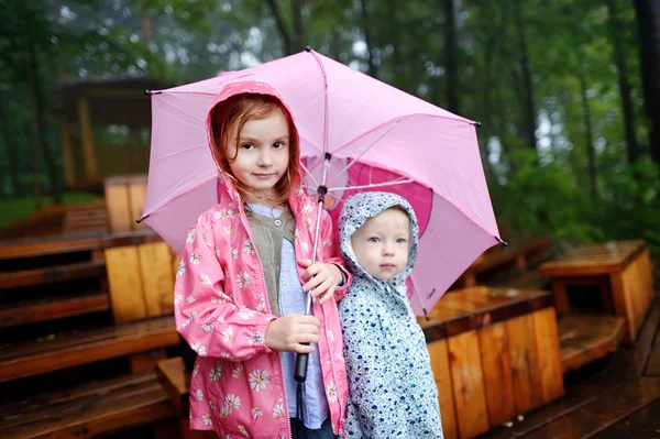 Twee zusters onder paraplu — Stockfoto