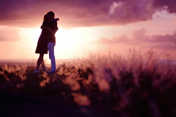 Pareja joven disfrutando de la puesta de sol —  Fotos de Stock