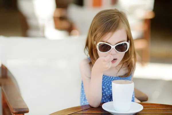 Uma menina bebendo chocolate quente no café ao ar livre — Fotografia de Stock