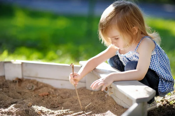 Girl playing in a sandbox — Stock Photo, Image