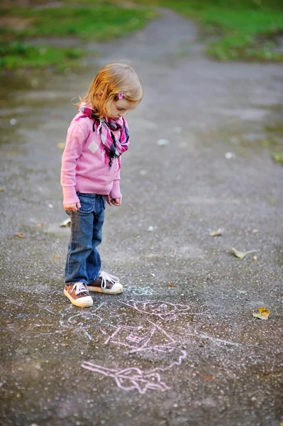 Petite fille regardant un dessin à la craie — Photo
