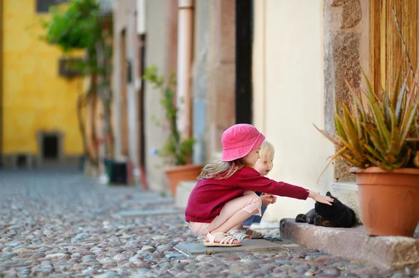 Zwei kleine Schwestern und eine Katze — Stockfoto