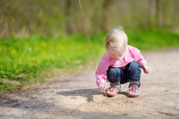 Malá dívka si hraje s holí — Stock fotografie