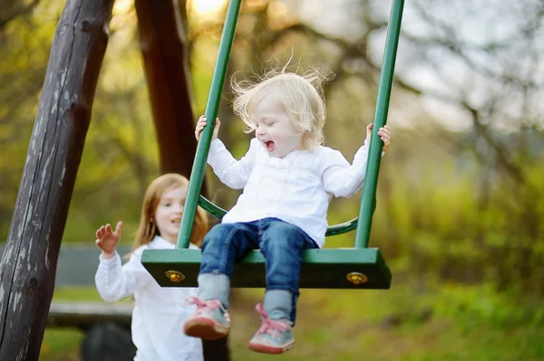 Little sisters  on swing — Stock Photo, Image