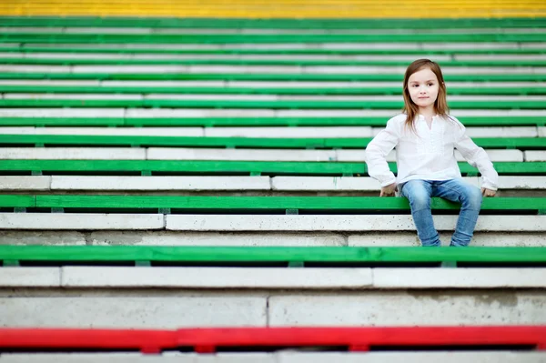 Девушка сидит на стадионе — стоковое фото