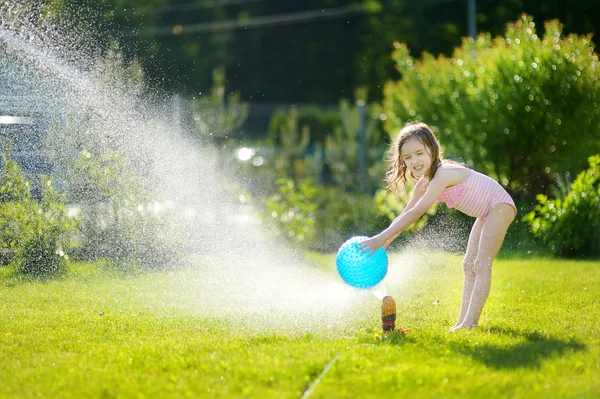 Mädchen läuft durch Sprinkleranlage — Stockfoto