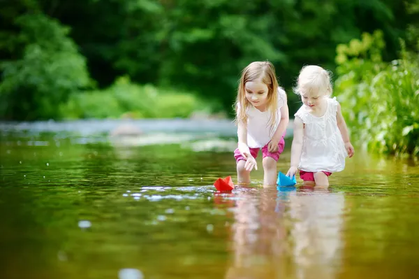 Sestry hrát s papírové lodě — Stock fotografie