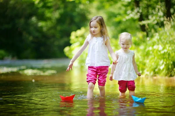 Sisters playing with paper boats — Stock Photo, Image