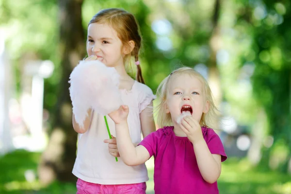 Маленькие сестры едят сладкую нитку — стоковое фото