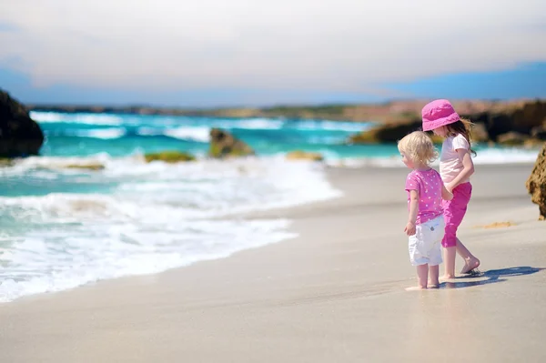 Две маленькие сестры на пляже — стоковое фото