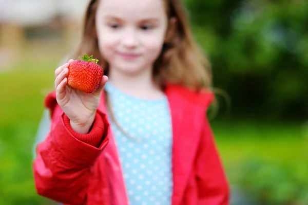 Mała dziewczynka gospodarstwa truskawka — Zdjęcie stockowe